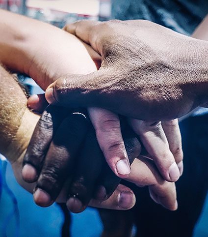 Manos de diversos tonos de piel unidas en apoyo